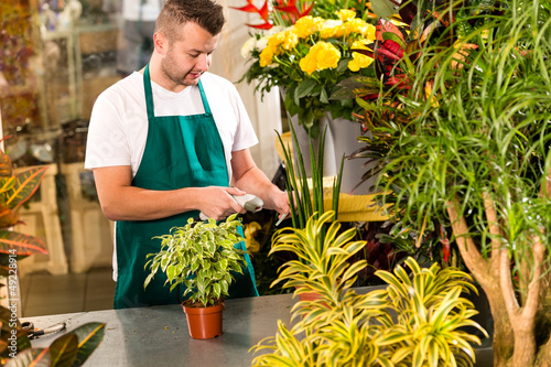 Photo: Man florist reading price barcode reader flower Man florist reading price barcode reader flower