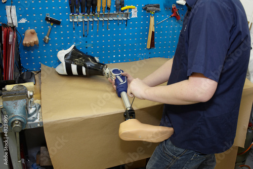 Photo: A technician adjusts a prosthetic foot. A technician adjusts a prosthetic foot.
