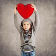 Young girl with red heart on grunge background.