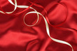 Red and white ribbon on a red silk