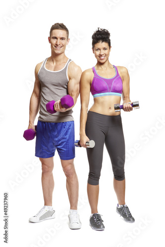Photo: Young man and woman exercising in sports outfits Young man and woman exercising in sports outfits