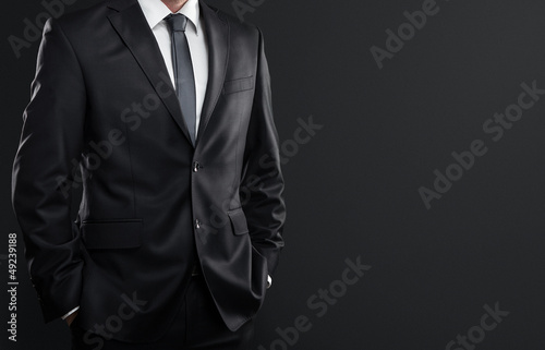 Photo: Close up of businessman over dark gray background Close up of businessman over dark gray background