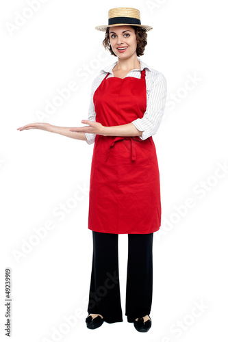 Photo: Pretty model in bakers apron presenting Pretty model in bakers apron presenting