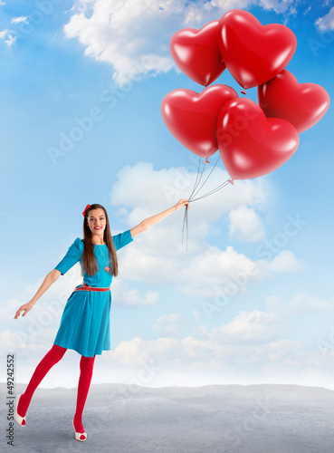 Photo: Woman holding a group of heart shaped balloons Woman holding a group of heart shaped balloons