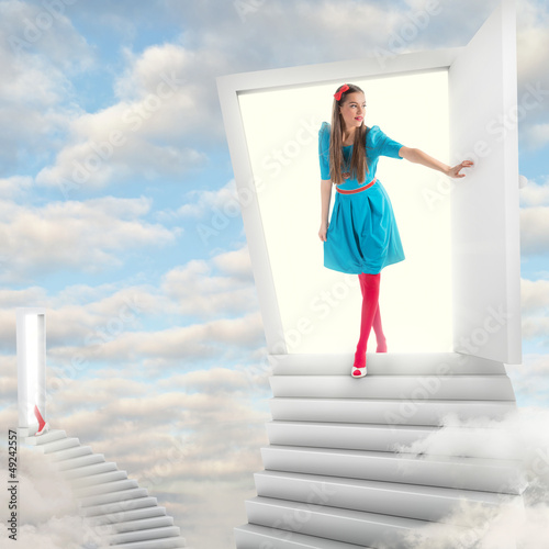 Photo: Girl walking through a magic door in sky Girl walking through a magic door in sky