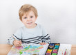 Cute little boy of two years having fun painting