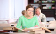 Young woman studying at desk with lots of books