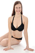 Junge Frau in schwarzem Bikini sitzt