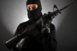 Vermummter Mann mit Maschinengewehr