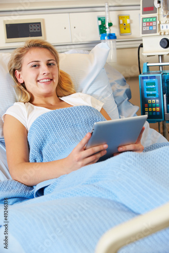 Photo: Teenage Female Patient In Hospital Bed With Digital Tablet Teenage Female Patient In Hospital Bed With Digital Tablet