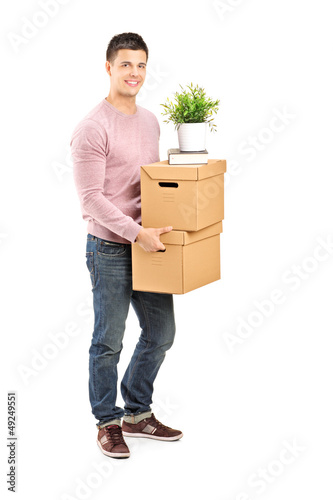 Photo: Full length portrait of a young man carrying removal boxes Full length portrait of a young man carrying removal boxes