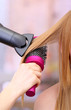 Beautiful woman and hands with hairdryer in beauty salon
