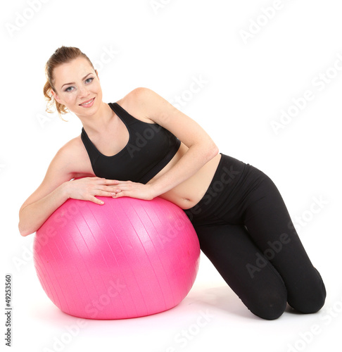Photo: Young woman doing fitness exercises with gym ball isolated Young woman doing fitness exercises with gym ball isolated