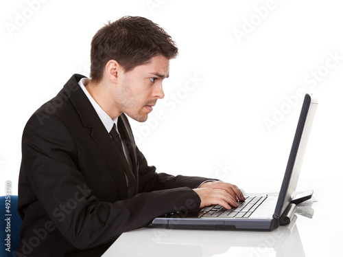 Photo: Young businessman seated at his desk Young businessman seated at his desk