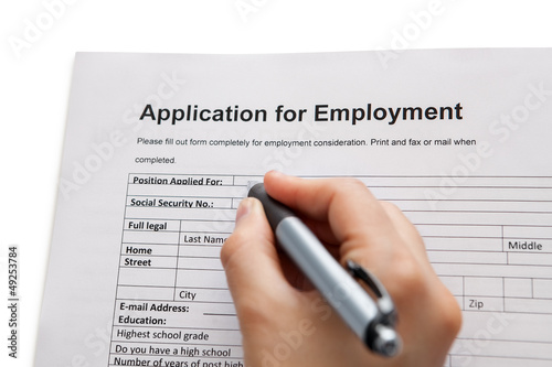 Photo: Male hand completing a job application Male hand completing a job application