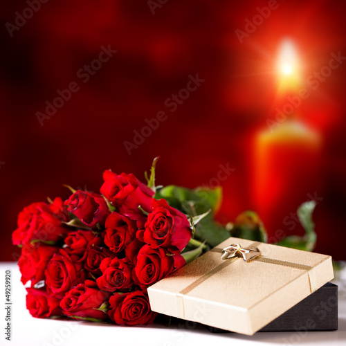 Photo: Rosen und Geschenkbox vor Kerzenschein Rosen und Geschenkbox vor Kerzenschein