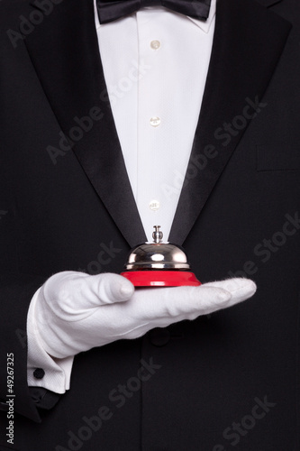 Photo: Waiter holding a service bell. Waiter holding a service bell.