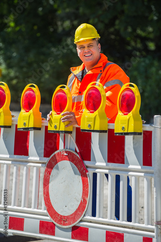 Photo: Arbeiter überprüft die Baustellenabsperrung Arbeiter überprüft die Baustellenabsperrung