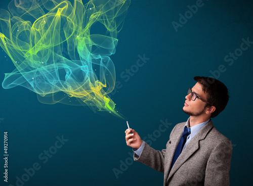 Photo: Handsome man smoking cigarette with colorful smoke Handsome man smoking cigarette with colorful smoke