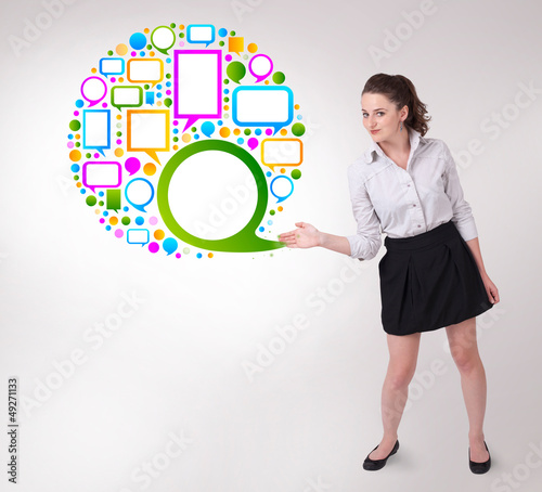 Photo: Young business woman presenting colourful speach bubble Young business woman presenting colourful speach bubble