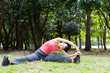 attractive asian woman stretching the park
