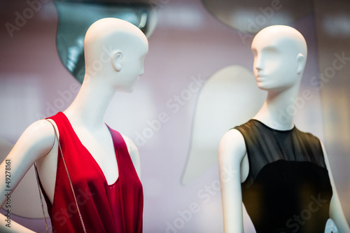 Photo: Two woman mannequins in shopping window in store Two woman mannequins in shopping window in store