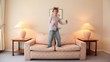 Video: Little boy jumps on sofa at room with lamps on each side Little boy jumps on sofa at room with lamps on each side