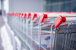 Photo: Rows of shopping carts on car park near entrance of supermarket Rows of shopping carts on car park near entrance of supermarket