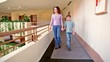 Mother And Son Walk Along Corr...