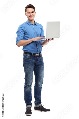 Photo: Young man holding laptop Young man holding laptop
