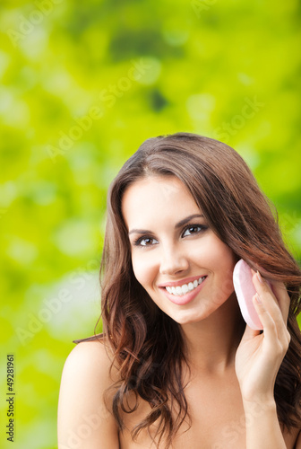 Photo: Woman cleaning skin by cotton pad, outdoor Woman cleaning skin by cotton pad, outdoor