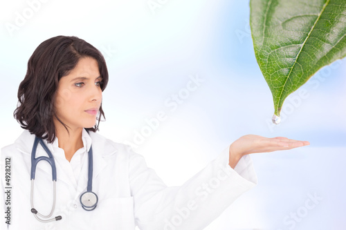 Photo: Doctor reaching out to dew drop falling from leaf Doctor reaching out to dew drop falling from leaf