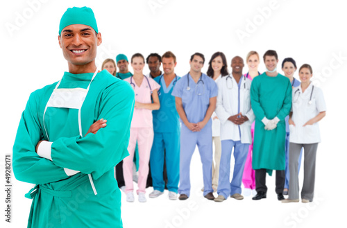 Photo: Smiling surgeon with medical staff behind him Smiling surgeon with medical staff behind him