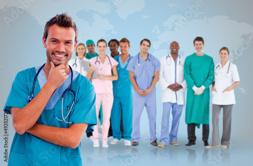 Photo: Happy doctor with medical staff behind him Happy doctor with medical staff behind him