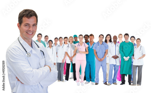 Photo: Smiling doctor in front of a team of doctors standing together Smiling doctor in front of a team of doctors standing together