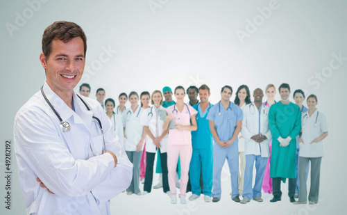 Photo: Smiling doctor in front of a team of doctors standing together Smiling doctor in front of a team of doctors standing together