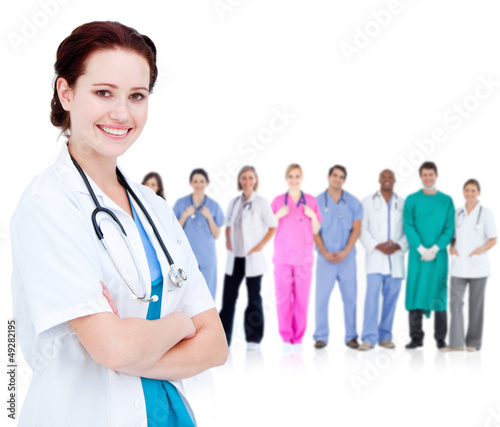 Photo: Smiling doctor in front of a team of doctors standing together Smiling doctor in front of a team of doctors standing together