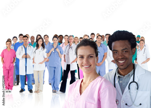 Photo: Smiling doctors in front of a team of doctors standing together Smiling doctors in front of a team of doctors standing together