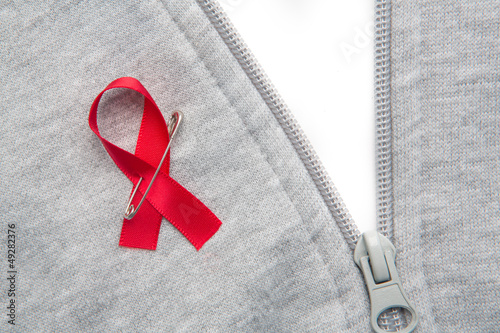 Photo: Aids awareness ribbon pinned on to grey zip jumper Aids awareness ribbon pinned on to grey zip jumper