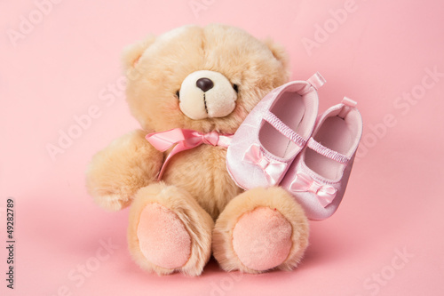 Photo: Fluffy teddy with pink ribbon and baby booties Fluffy teddy with pink ribbon and baby booties