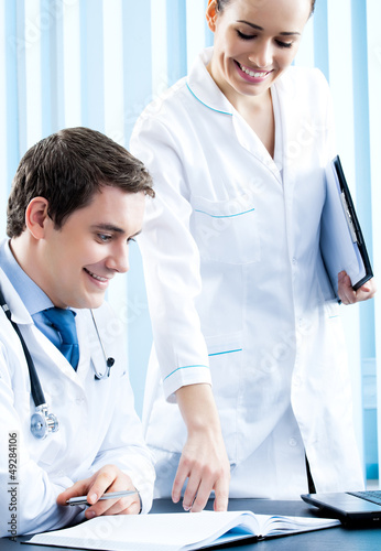 Photo: Two happy medical people working at office Two happy medical people working at office