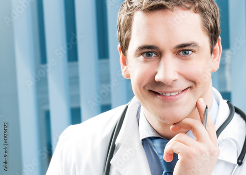 Photo: Happy smiling young doctor at office Happy smiling young doctor at office