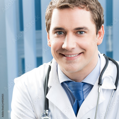Photo: Happy smiling young doctor at office Happy smiling young doctor at office