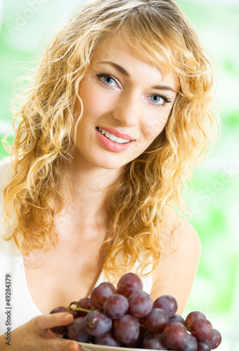 Photo: Young happy woman with plate of grape Young happy woman with plate of grape
