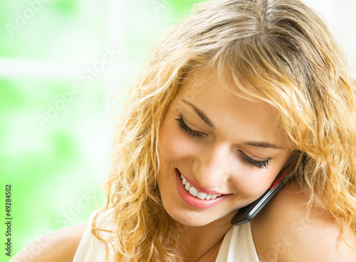 Photo: Happy smiling woman talking on cellphone Happy smiling woman talking on cellphone