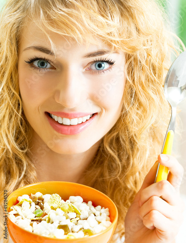 Photo: Cheerful woman eating cereal muslin Cheerful woman eating cereal muslin