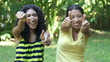 Two young women giving thumbs up.