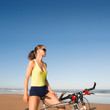 Junge Frau am Strand mit Fahrrad