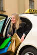 Young woman gets out of taxi