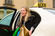 Young woman gets out of taxi